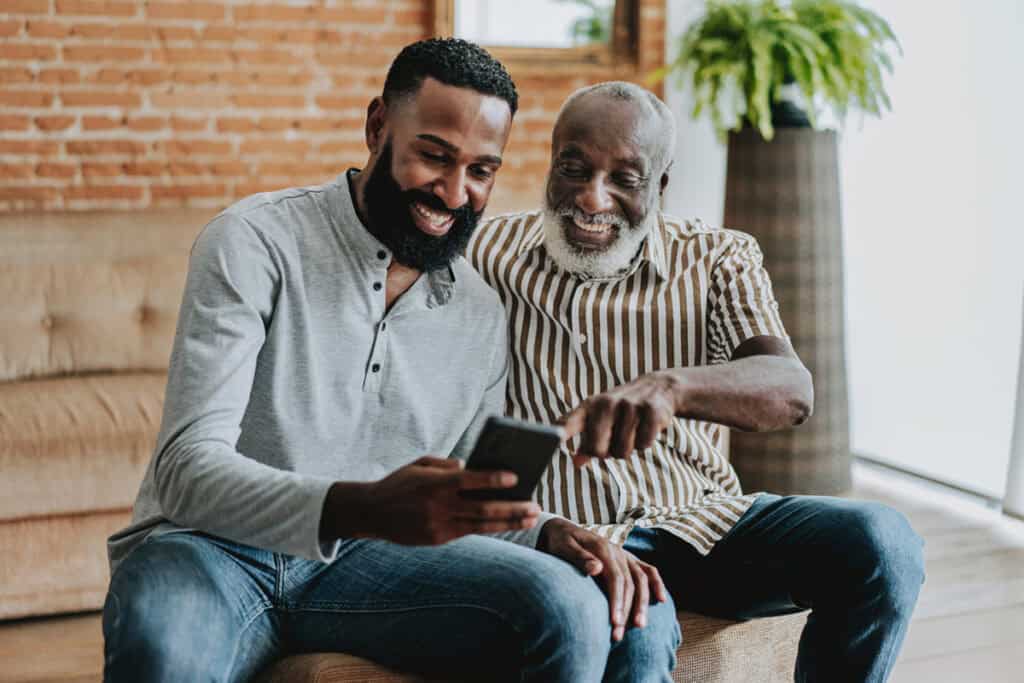 Two men looking at a phone.